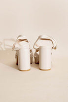 Elegant white cross ankle strap heels with block heels and adjustable straps for a stylish look