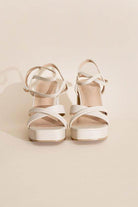 Stylish white cross ankle strap heels with a platform design for women's footwear collection