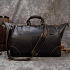 Brown leather travel shoulder bag with sturdy handles and removable shoulder strap for convenience