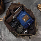 Spacious travel shoulder bag from VacationGrabs filled with clothes, a camera, and a laptop for easy packing