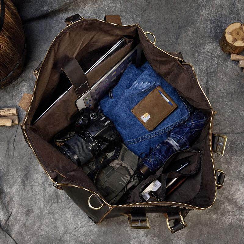 Spacious travel shoulder bag from VacationGrabs filled with clothes, a camera, and a laptop for easy packing