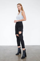 Insane Gene trendy black ripped jeans styled with a fitted top and ankle boots for a chic look