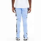 Back view of trendy leather stripe joggers in light blue with black side stripes worn by male model