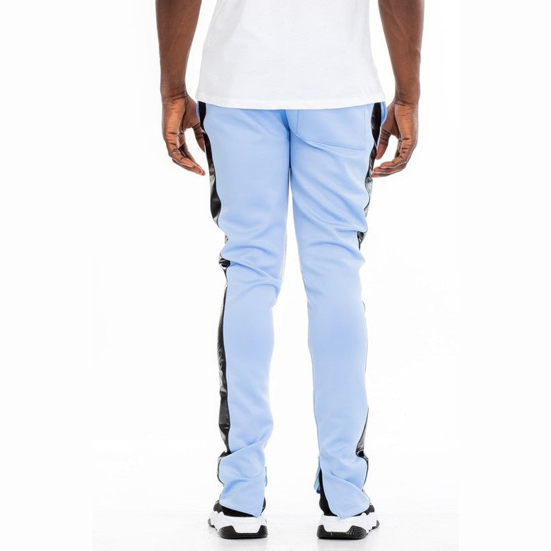 Back view of trendy leather stripe joggers in light blue with black side stripes worn by male model