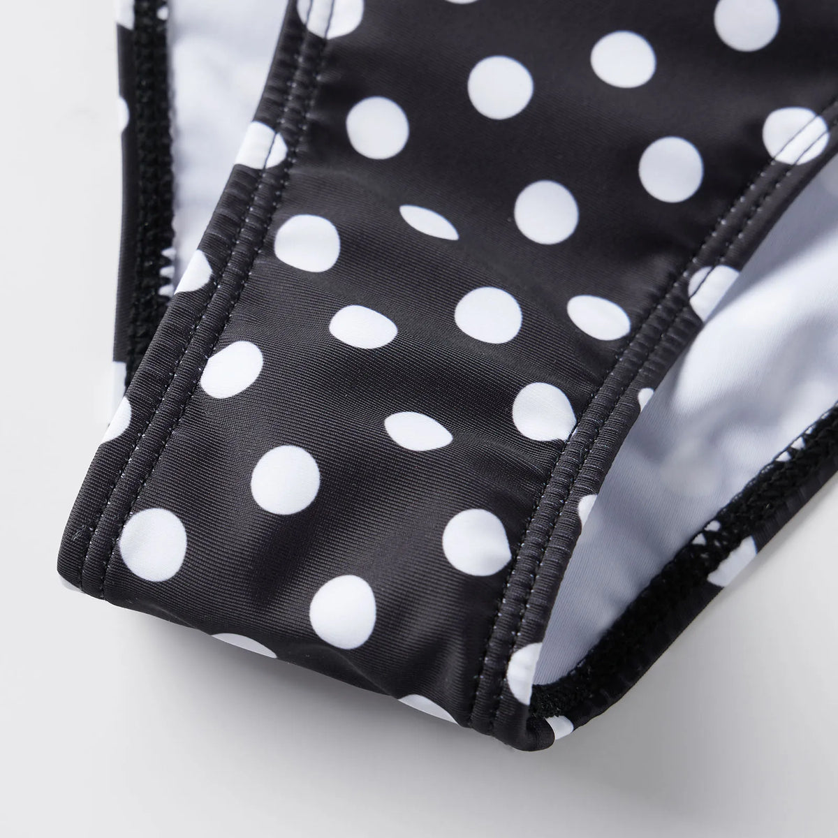 Black and white polka dot tummy control swimsuit for flattering beachwear