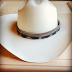 Turquoise Navajo leather hat band on a white cowboy hat, adding a stylish touch.
