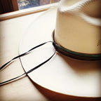 Turquoise Navajo leather hat band on a wide-brimmed straw hat for a stylish look