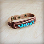 Turquoise stone cuff bracelet on brown leather strap with metal snaps for a stylish look