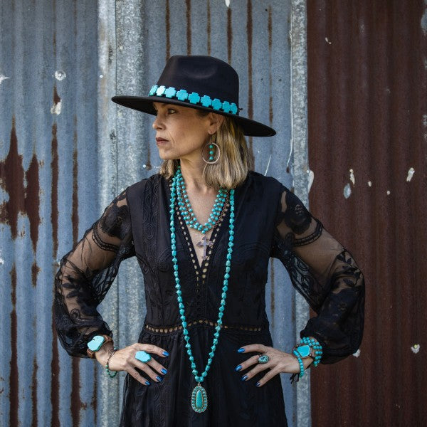 Stylish model wearing a turquoise triple strand bracelet with matching turquoise jewelry