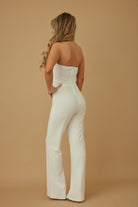 Elegant white twisted rope knot jumpsuit with a fitted bodice and flared legs, perfect for stylish summer outings