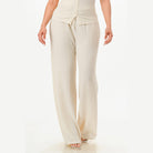 Cream textured two piece lounge set for travel featuring wide leg pants and buttoned top