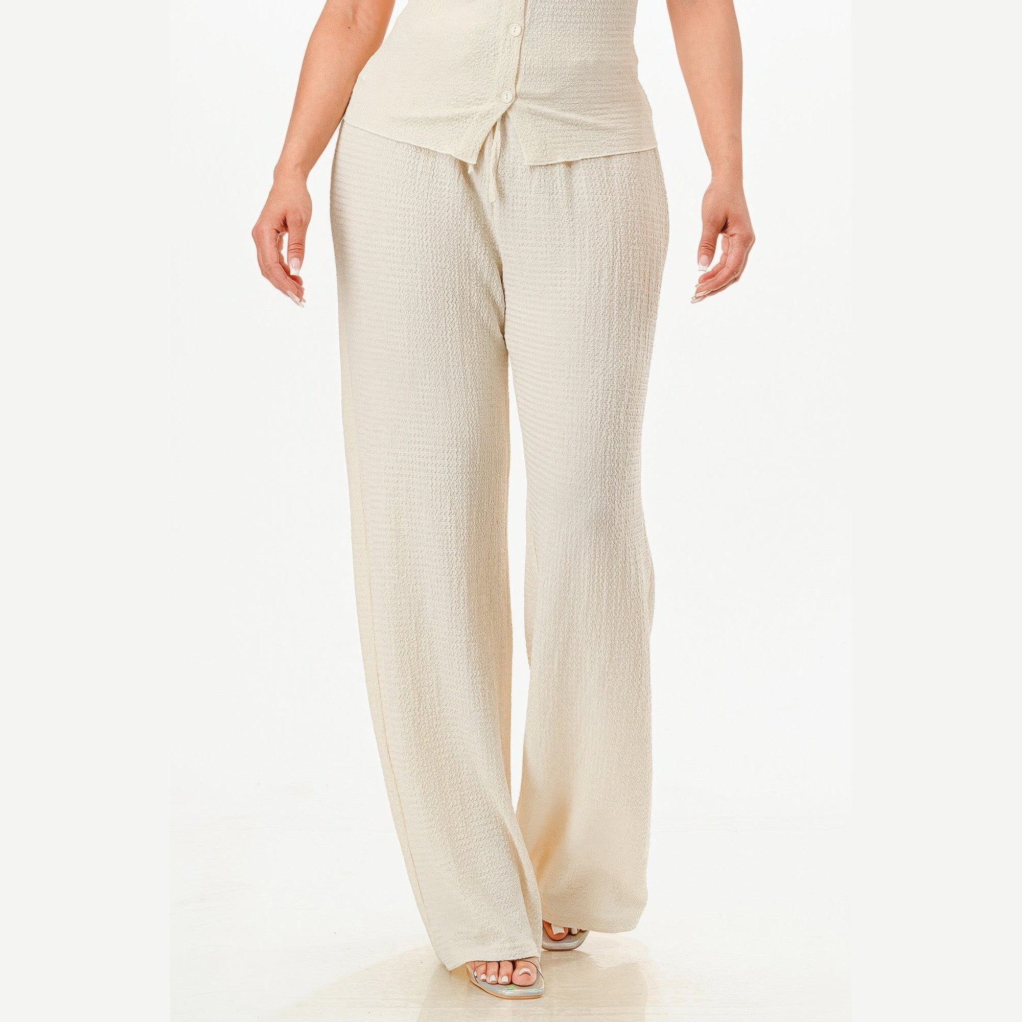 Cream textured two piece lounge set for travel featuring wide leg pants and buttoned top