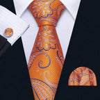 Men's orange tie with unique necktie designs featuring floral patterns, paired with a matching pocket square