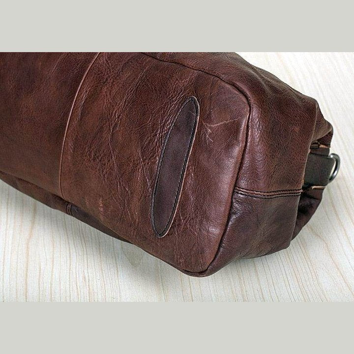 Brown leather unisex shoulder bag for travel with a spacious design and sturdy stitching
