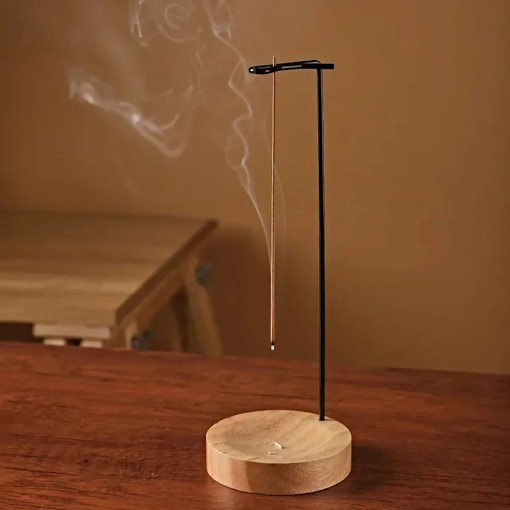 Upside down incense burner with a wooden base and black metal stand
