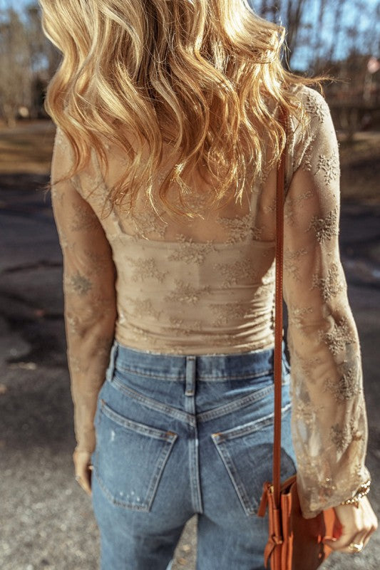 YNique lace mesh long sleeve blouse in beige sheer floral embroidery shown from back with high waist jeans