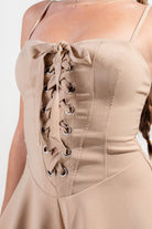 Beige vacation outfit jumpsuit for women featuring a lace-up front and elegant design