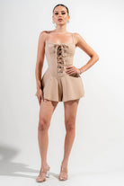 Beige vacation outfit jumpsuit for women with a front lace-up design and flared shorts