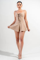 Stylish beige vacation outfit jumpsuit for women with lace-up detail and flared shorts