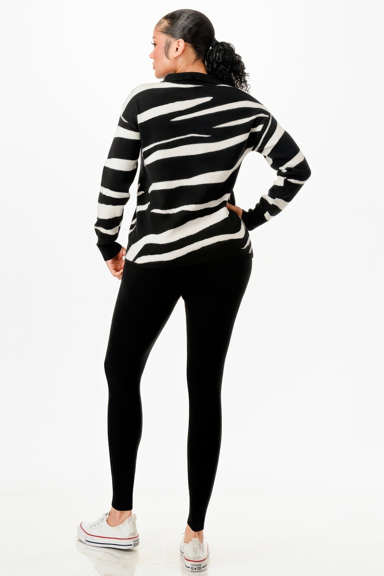 Trendy black and white striped sweater with black leggings, ideal vacation outfits for women