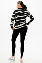 Trendy black and white striped sweater with black leggings, ideal vacation outfits for women