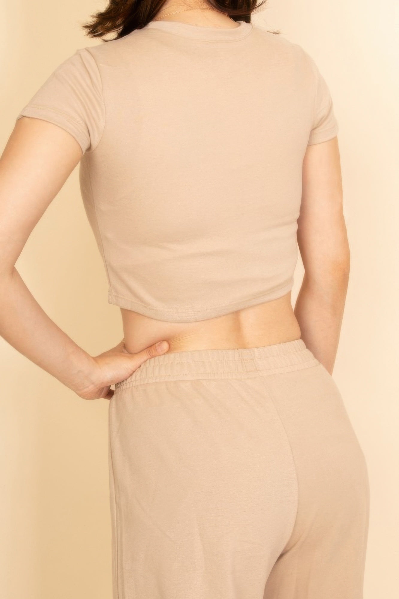 Casual beige women's outfit set featuring a cropped top and matching pants, ideal vacation outfits for women