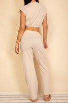 Back view of a women's cream cropped top and wide-leg pants set, ideal vacation outfits for women