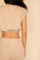 Back view of a beige women's outfit set, perfect vacation outfits for women with a cropped top and soft pants