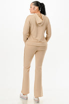 Woman wearing beige vacation ready matching sweatsuit with hoodie and pants from VacationGrabs