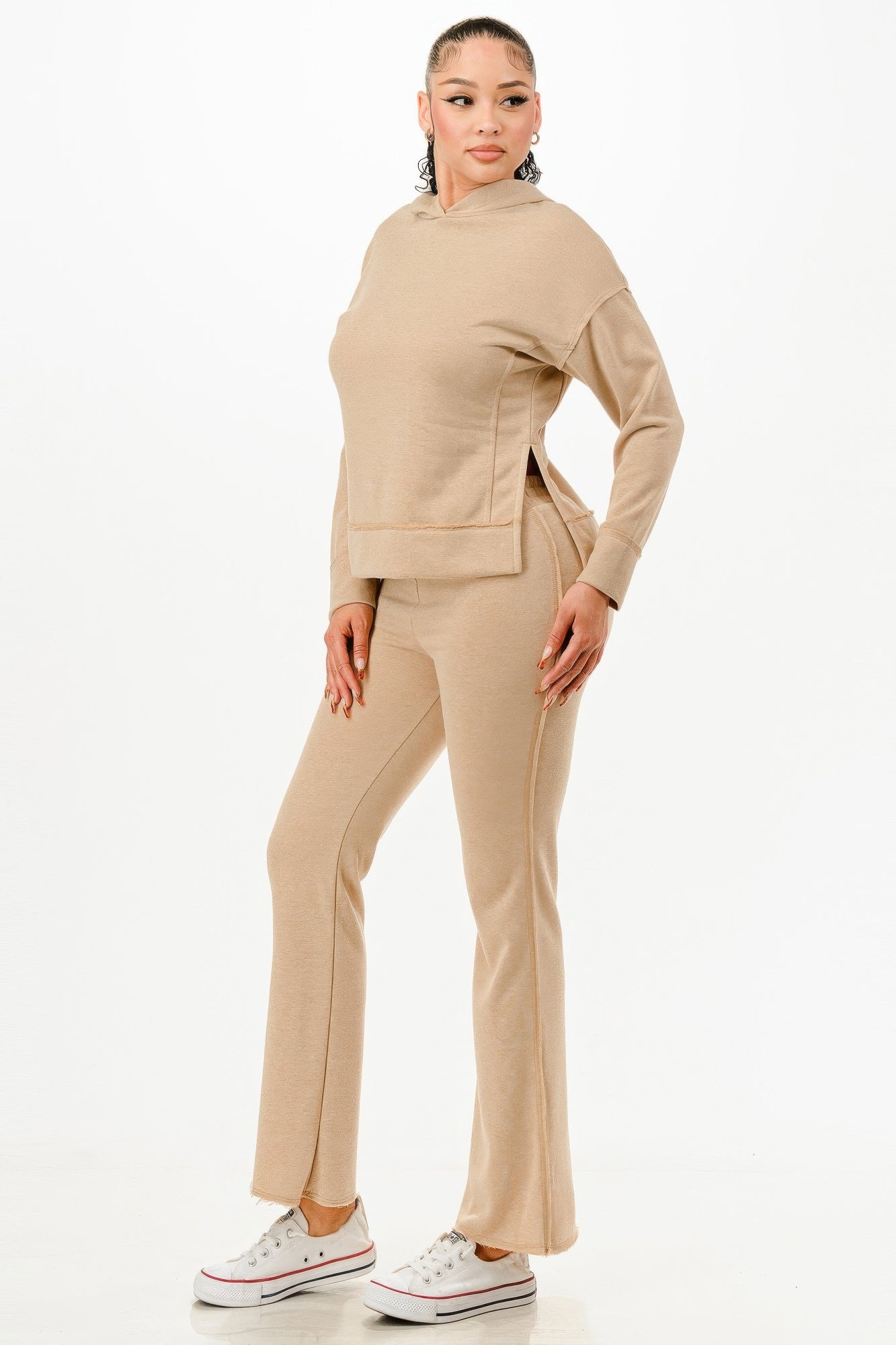 Woman wearing beige vacation ready matching sweatsuit with hoodie and flared pants from VacationGrabs