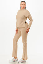 Woman wearing beige vacation ready matching sweatsuit with hoodie and flared pants from VacationGrabs