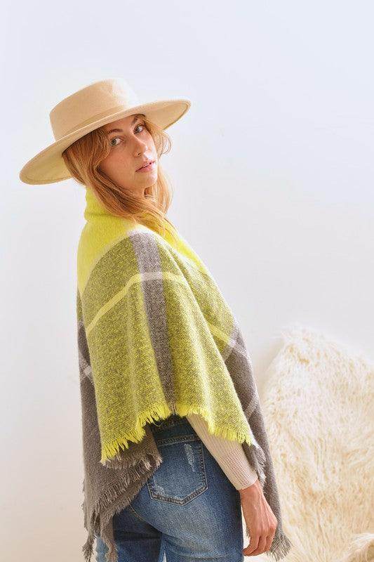 Bella Chic women's vacation style accessory, a cozy poncho in yellow and gray, perfect for travel