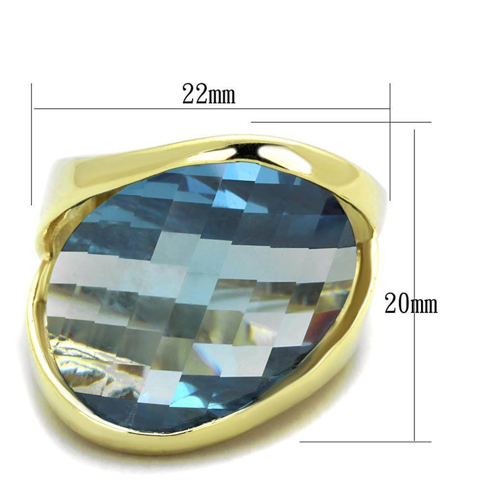 Vacation style gold statement ring featuring a large faceted blue gemstone in a sleek design