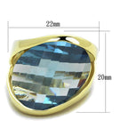 Vacation style gold statement ring featuring a large faceted blue gemstone in a sleek design