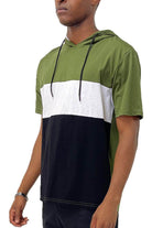 Vacation style hooded t-shirt in green, white, and black colorblock design for casual outings