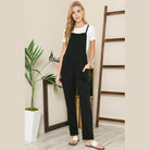 Stylish women's vacation style overalls in black with pockets, paired with a white tee for a chic look