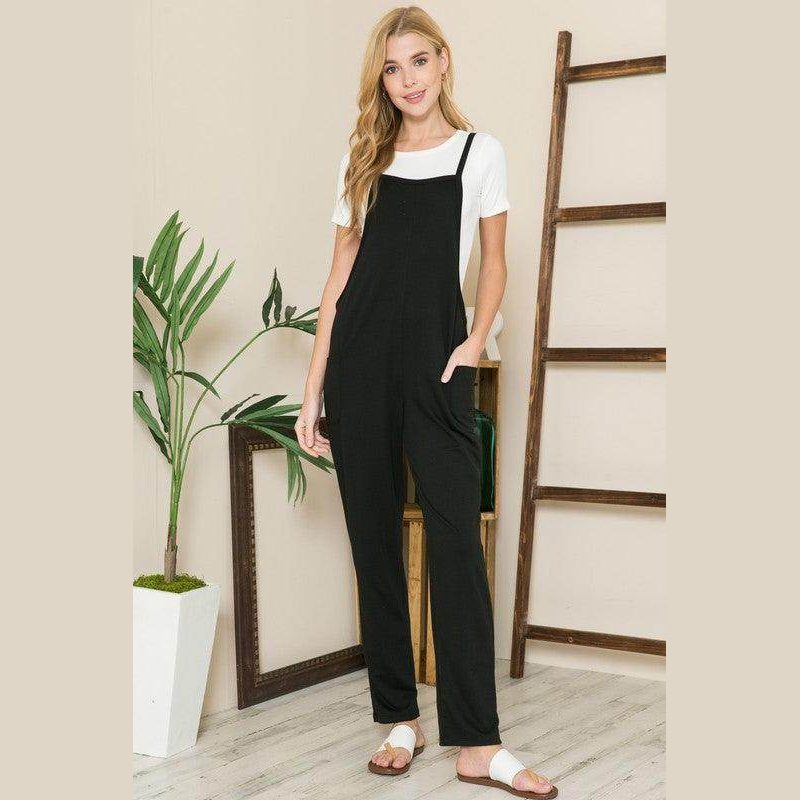Stylish women's vacation style overalls in black with pockets, paired with a white tee for a chic look