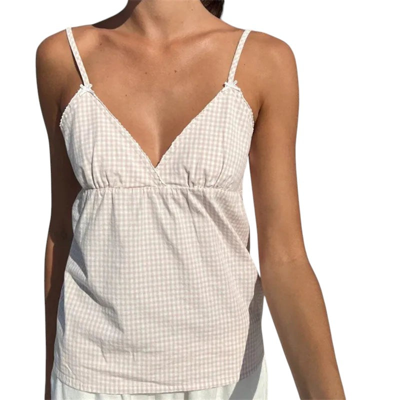 VacationGrabs beige gingham peplum camisole with lace trim, spaghetti straps, and a V-neck on a sunny beach.