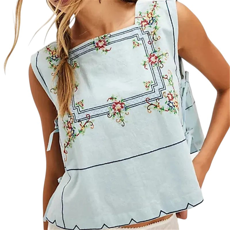 VacationGrabs light blue embroidered floral crop top with a square neckline and tie-up sides for a Y2K vacation look.