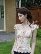 VacationGrabs floral corset top with puff sleeves and lace trim worn by a woman in a garden setting