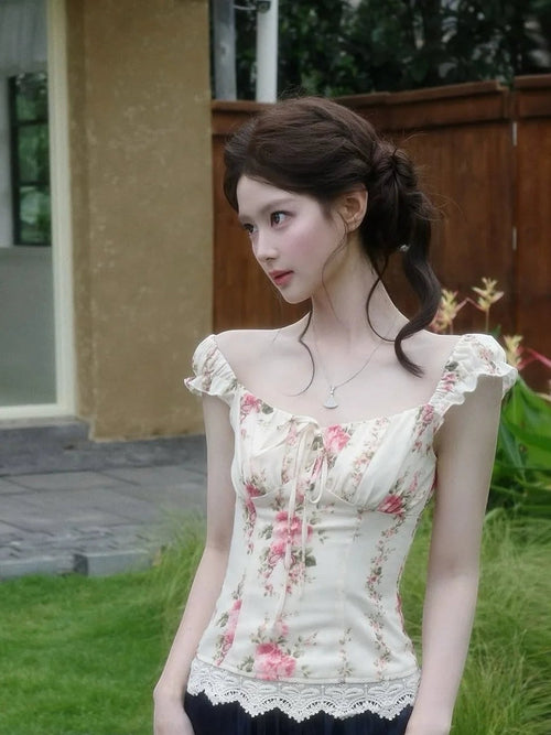 VacationGrabs floral corset top with puff sleeves and lace trim worn by a woman in a garden setting