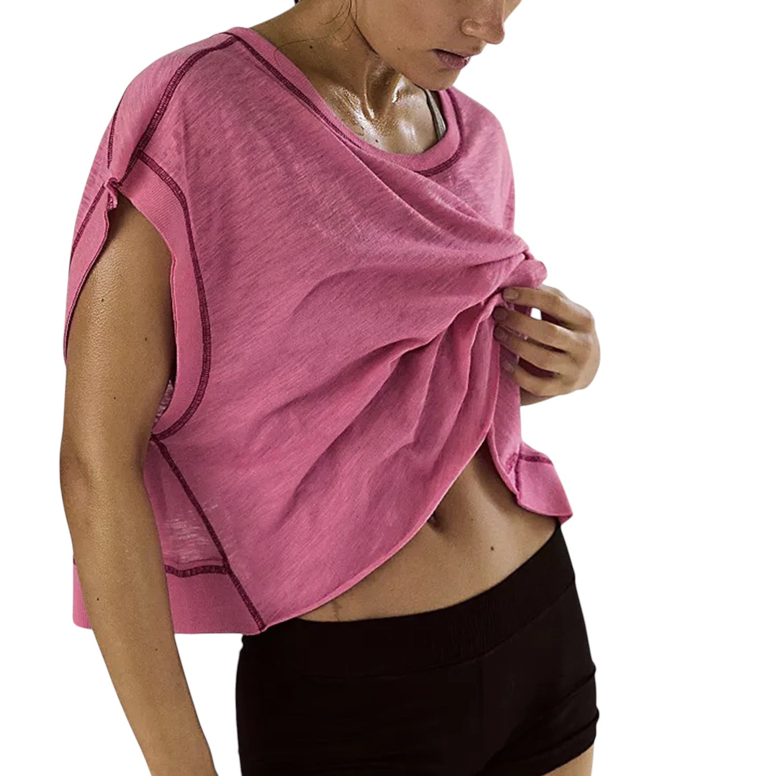 VacationGrabs pink short-sleeve crop top with exposed seam detailing, worn by a woman with black athletic shorts.