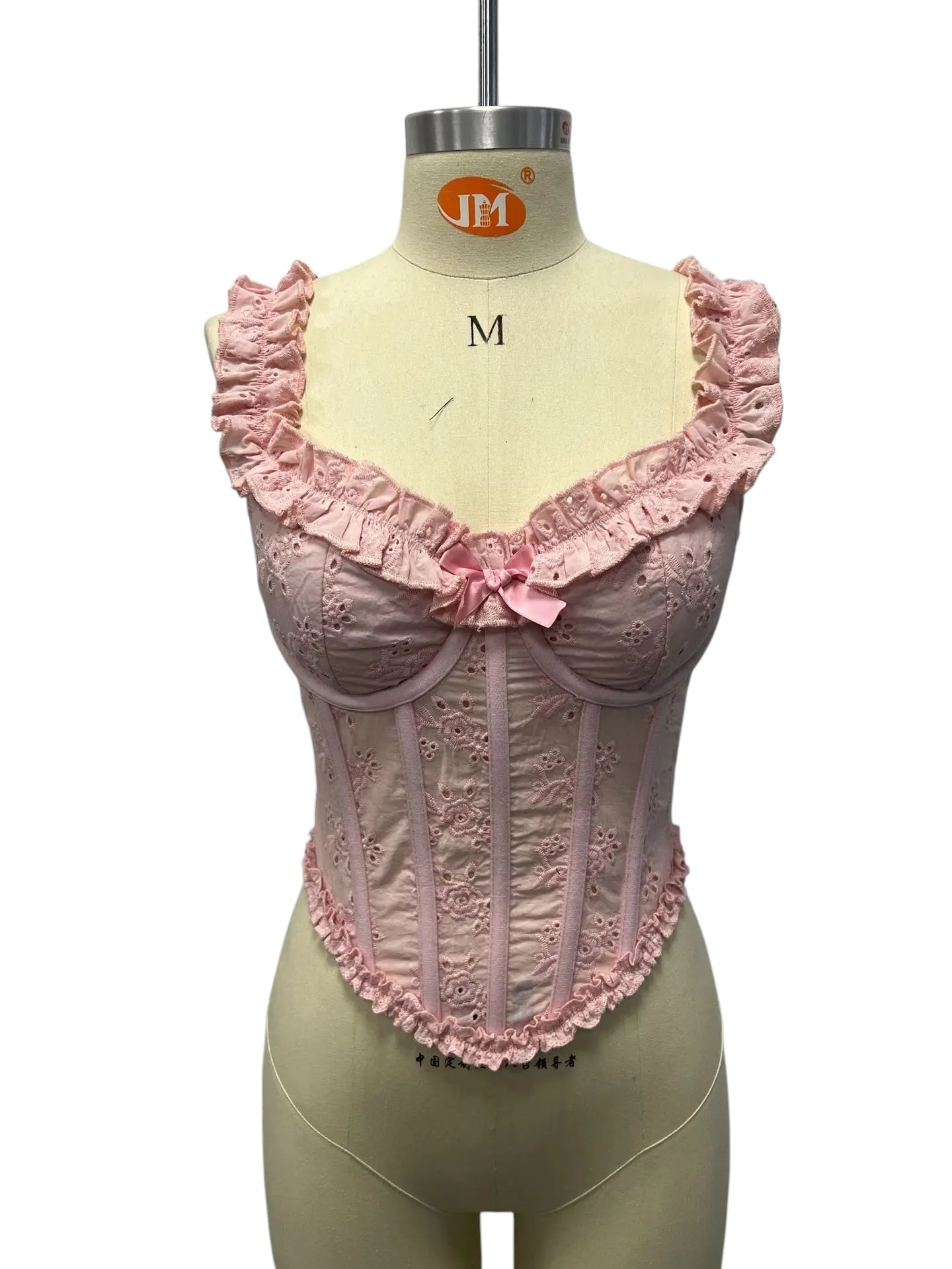 VacationGrabs pink eyelet corset top with ruffled straps and a small bow detail on a dress form