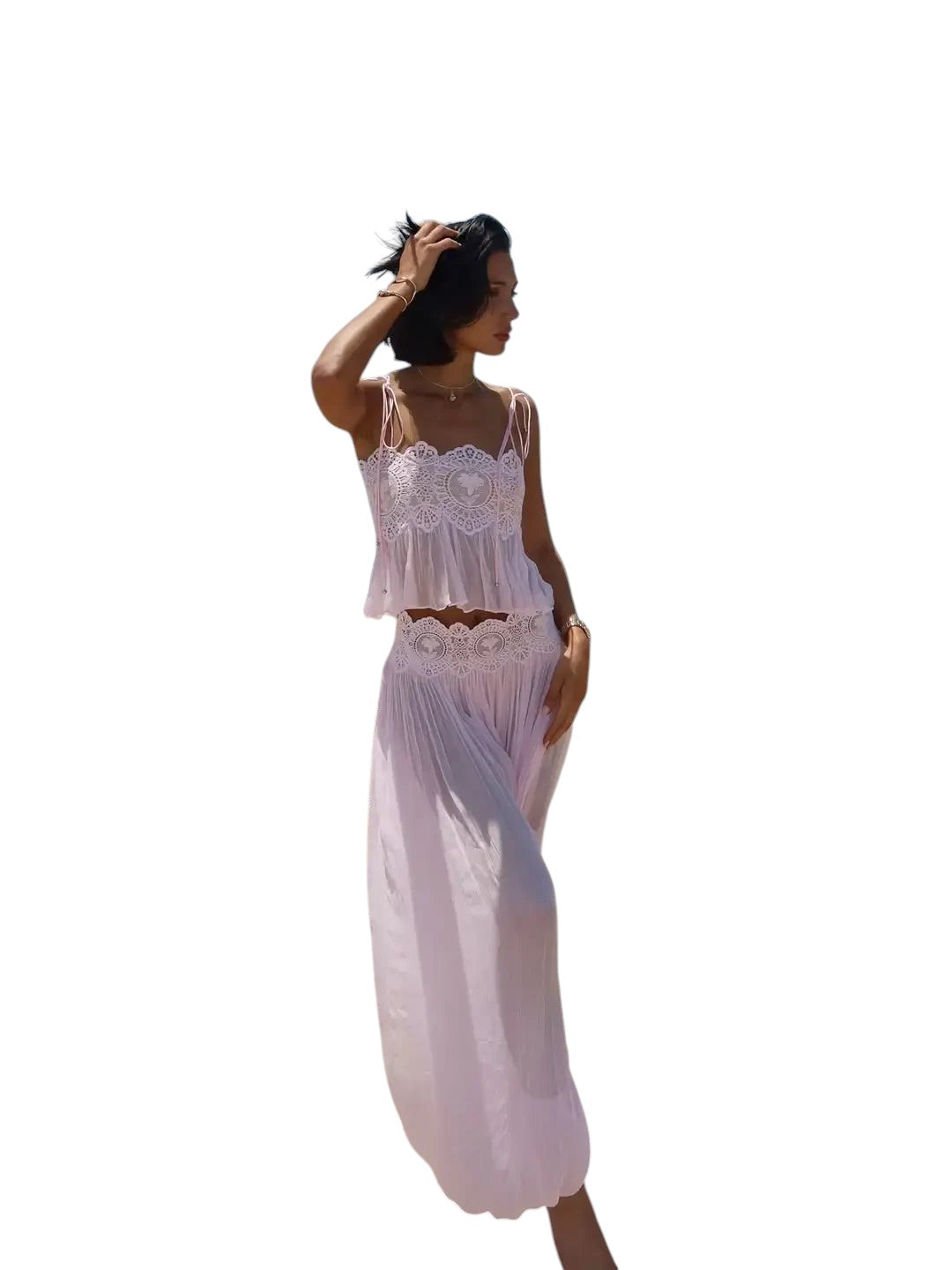 VacationGrabs light pink two-piece set with lace-trimmed camisole and flowy maxi skirt worn by a woman on the beach.
