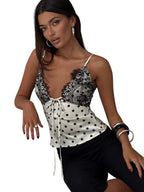 VacationGrabs polka dot cami top with black lace trim and front tie detail worn by a model in a studio setting.