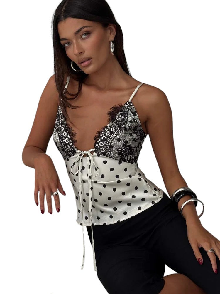 VacationGrabs polka dot cami top with black lace trim and front tie detail worn by a model in a studio setting.