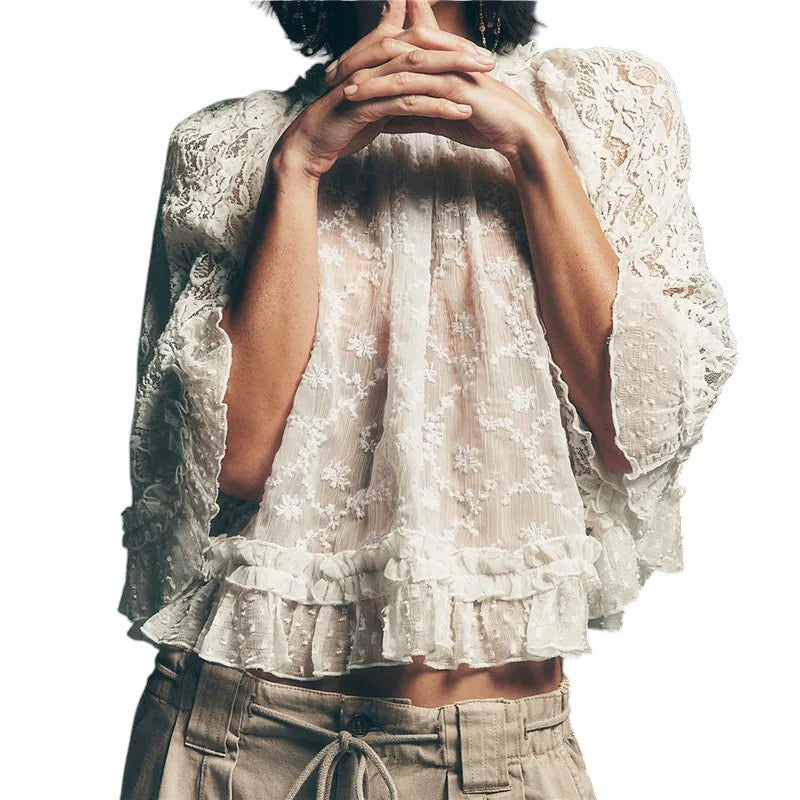 VacationGrabs white lace boho blouse with flared sleeves and ruffle hem worn with beige trousers