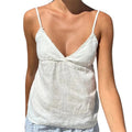 VacationGrabs white lace trim peplum camisole with spaghetti straps and V-neck worn on a sunny beach
