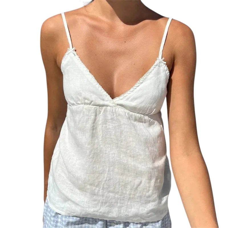 VacationGrabs white lace trim peplum camisole with spaghetti straps and V-neck worn on a sunny beach