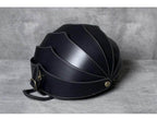 Accordion beetle daypack in sleek black design with unique shell-inspired shape for stylish travel